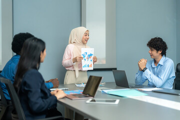 Professional presenting a chart to colleagues during a team meeting, focusing on business strategy, collaboration, and data analysis.