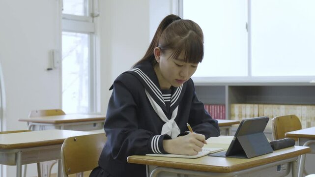 教室で勉強をする若い日本人の学生
