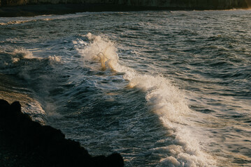 Close up shot of the waves in the sea and reflection of sunlight in the water
