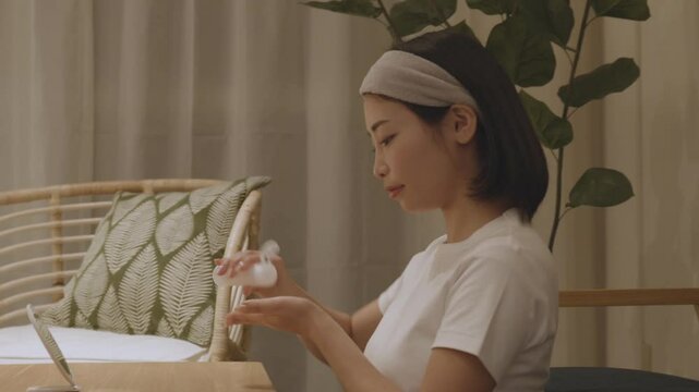 夜の部屋で美容ケアをする若い女性
