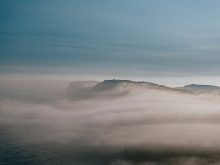 Fog and clouds over the mountains of the island in the sea