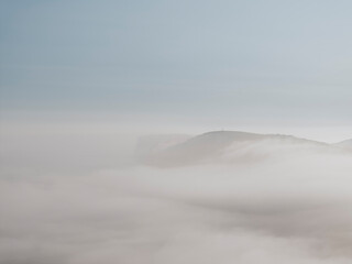 Dense fog and clouds over the mountains of the island in the sea
