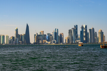 Obraz premium Beautiful seaside view of skyscrapers and boats in the sea in Doha, Qatar