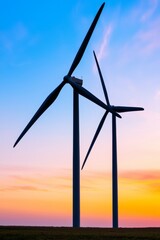 A silhouette of wind turbines in a countryside landscape during sunset. Wind power plant generating clean energy. Concept of renewable energy and sustainability.