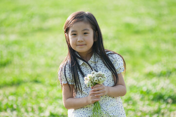 シロツメクサの花束を持つ女の子	