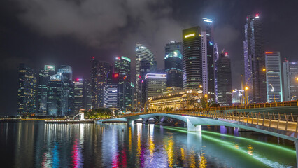 Fototapeta premium Esplanade bridge and downtown core skyscrapers in the background Singapore night timelapse hyperlapse