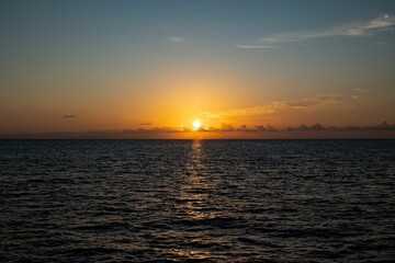 Serene ocean sunset with a vibrant orange sky and calm waves