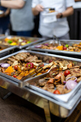 A vibrant buffet spread featuring grilled meats and vegetables at a festive gathering in an elegant venue during the evening