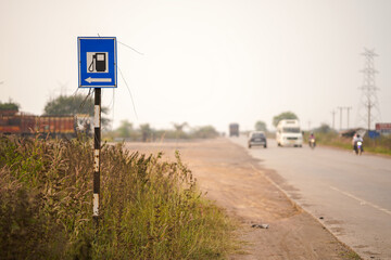 fuel station ahead sign, roadside gas station direction, highway fuel stop indicator, petrol pump signpost, rural highway fuel guide, road safety sign with grass, transportation route signage stock.
