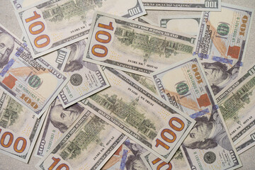 A US 100 dollar bill on top of a pile of scattered dollar bills, currency, texture and background.