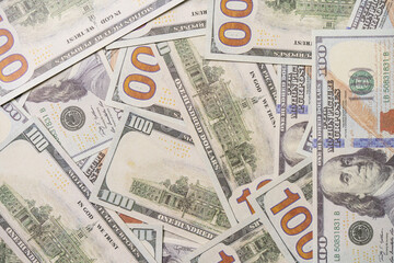 A US 100 dollar bill on top of a pile of scattered dollar bills, currency, texture and background.