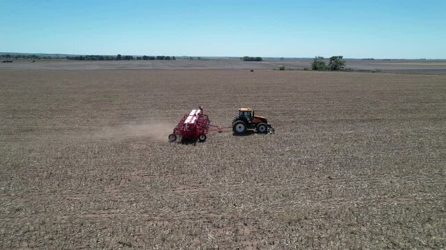 Agricultural mechanical seeders of grain crops. Tactor with a seeder sows grain in the field. A farmer on a tractor with a seeder processes the field.