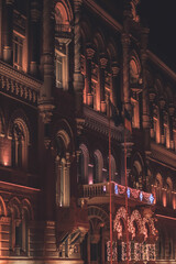 Historic building facade illuminated at night with decorative lights and arched windows, creating a...