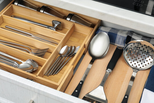 Box with cutlery in drawer, closeup. Kitchen utensils storage - Powered by Adobe