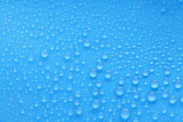 Water drops on blue background, top view