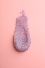 Smear of body scrub on light pink background, top view