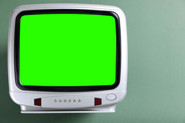Retro Tv set with green screen on color background, space for design. Chroma key