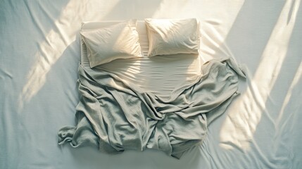 Simple bed on a white background, showcasing neat linens and pillow arrangement. Ideal for catalogs