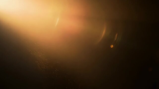 Play of golden sunlight with dramatic lens flare creates ethereal atmospheric background. Warm amber and sepia tones produce dreamlike cinematic mood. Overlay texture.
