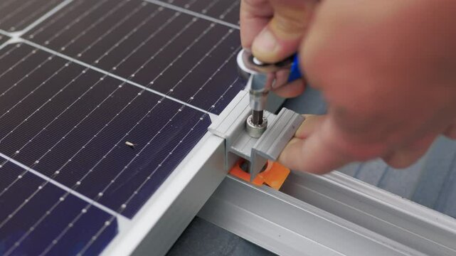 Close up of worker installing and working on maintenance of photovoltaic panel system installed. Mounting solar panel, installing solar panels on the roof of the house. Connection of solar panels