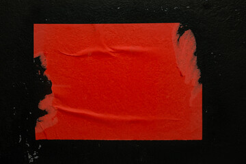 Red torn poster on black background.