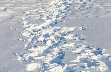 A snow-covered path with a trail of footprints
