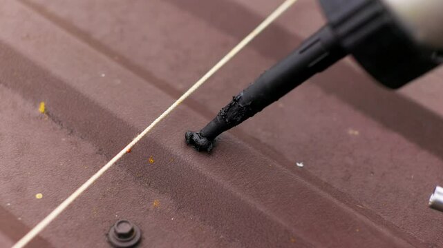 Close up of applying sealant on the roof. Carpenter repairing cabin roof of boat sealing leaks with mastic waterproof sealant