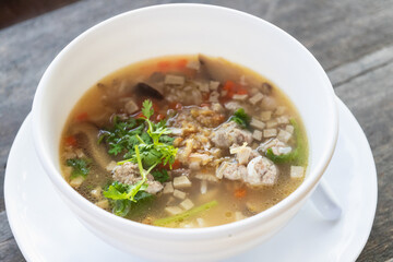 A delicious bowl of soup featuring minced meat, fresh herbs, and colorful vegetables, perfect for a comforting meal.