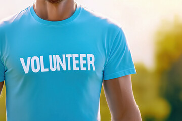 Close-up of a person wearing a blue t-shirt with "VOLUNTEER" written on it, representing community service, support, and social responsibility.