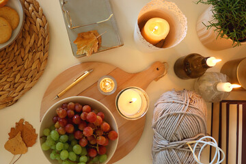 Pumpkins, various food and drinks, fall decorations, books and candles on the table. Fall hygge at home. Flat lay.