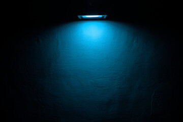 blue neon modern eco energy saving light bulb on concrete wall. Background texture of empty old cement wall with glowing green led lamp. night scene. empty copy space for inscription.