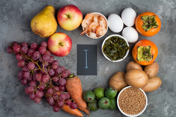Example of a range of food products containing iodine, I. The concept of a proper balanced diet. on a dark background, horizontally, top view.