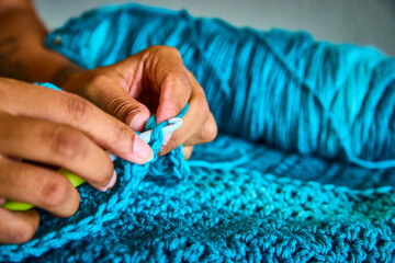 Hands Crocheting Blue Yarn with Intricate Patterns Eye Level View