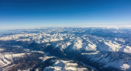 Obraz premium Aerial view of -capped mountains clear blue skies