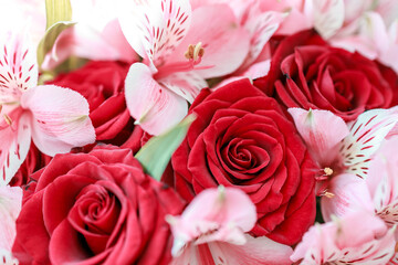 several rose flowers in a bouquet with lilies, a close-up of red flowers