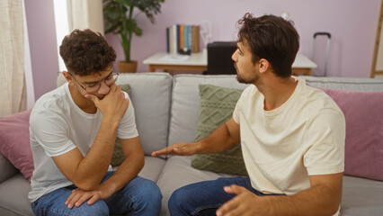 Father and son having a thoughtful conversation in a cozy living room, showcasing family love, male bonding, and expressing emotions indoors.