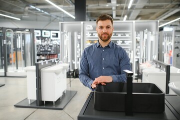 Fototapeta premium Portrait of salesperson in bathroom store. Happy man works in bath store. Sales occupation