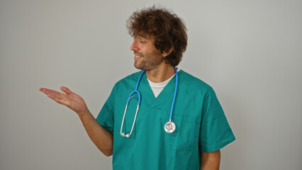 Young man in green scrubs and stethoscope smiling against isolated white background