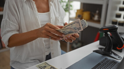 Woman handling cash while standing in a home decor store, highlighting a business transaction with...