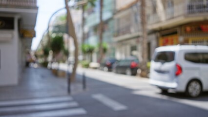 Blurred street scene with a white van and buildings in the background, captured in a sunny city that creates a soft bokeh effect and out-of-focus details showcasing an outdoor urban environment