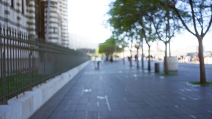 Blurred view of a defocused street scene in marseilles france with trees lining the sidewalk and people walking in the background outdoors during daytime
