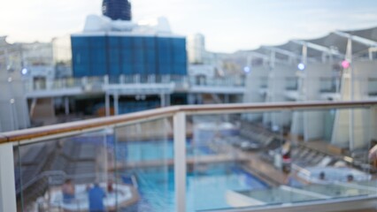 Blurred view of luxury cruise deck with out of focus railings and bokeh effect, capturing relaxed vacation atmosphere and poolside tranquility in the open air.