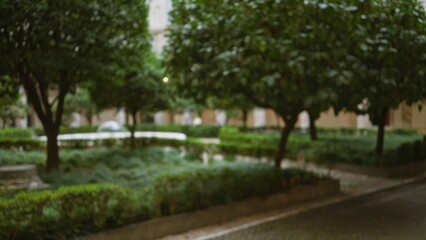 Blurred garden scene with lush greenery and defocused trees creating a serene outdoor bokeh effect in a tranquil patio setting, showcasing peaceful nature vibes.