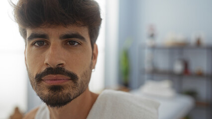 Obraz premium Handsome young man with a beard posing for a portrait inside a spa wellness center