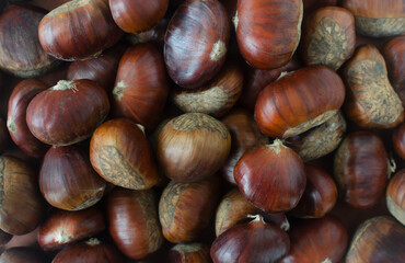Edible raw chestnuts on the table. The concept of autumn food. Street food. Selective focus. Horizontal orientation. Top view