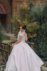 A woman in a white dress is standing on a bridge. She is wearing a white dress and a white scarf