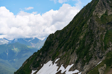 mountain tops with snow and clouds on blue sky 