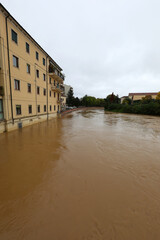 brown river lapping at city houses during a flood caused by torrential rains