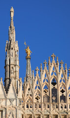 statue of the holy Virgin Mary called the Madonnina is located among the tall spires of the Gothic...