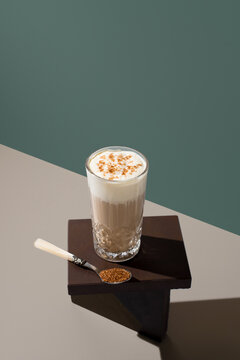 Glass of coffee with milk cream and brown sugar on dark surface